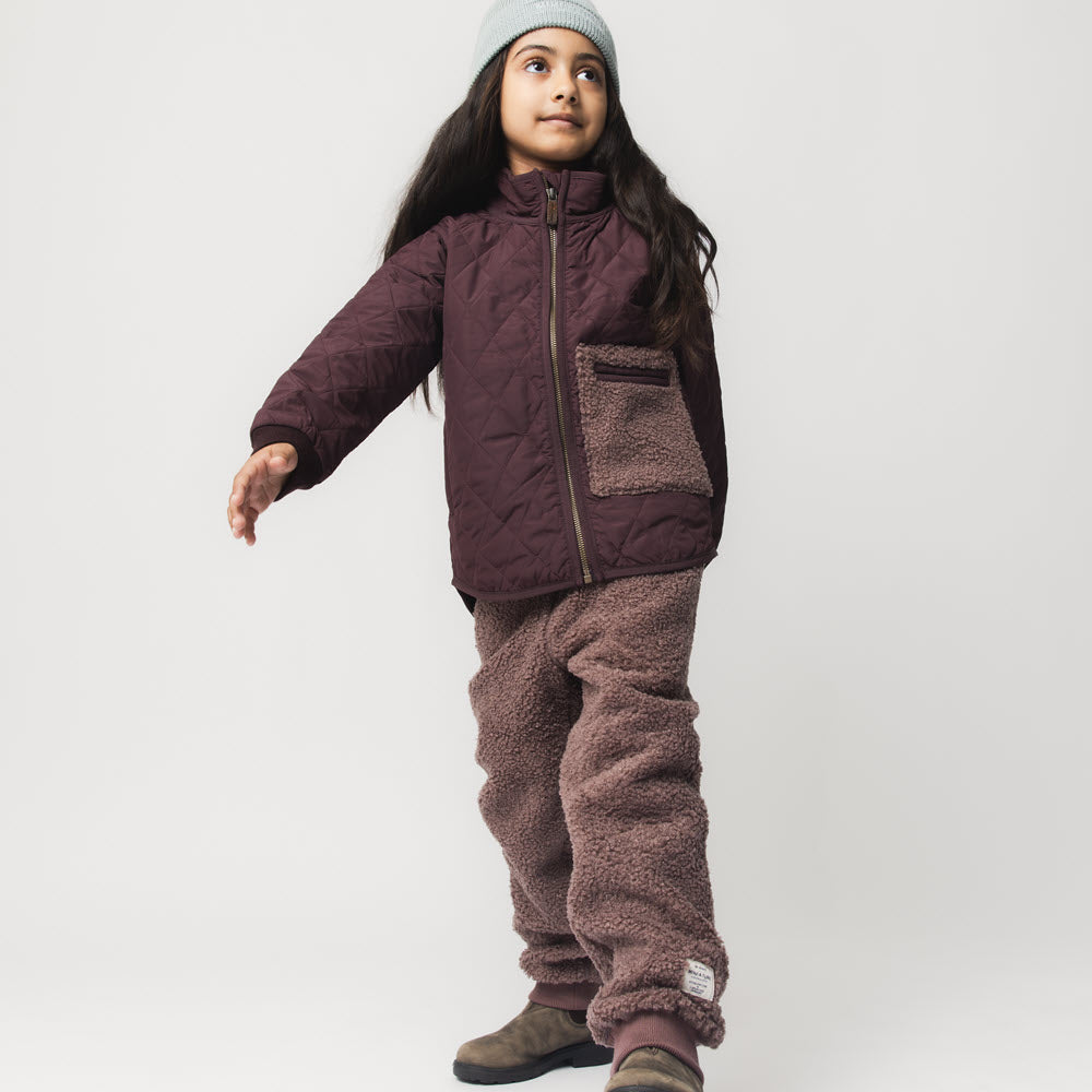 Child wearing MATVALUR teddyfleece pants in Peppercorn plum